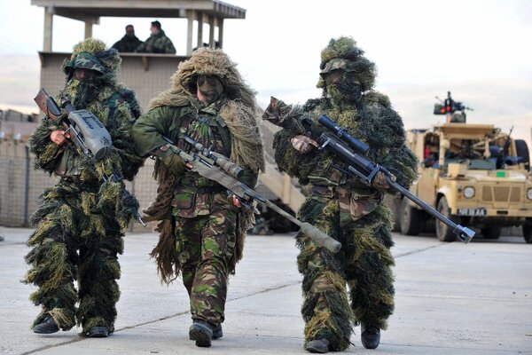 Drei Soldaten in Tarnung mit einer Waffe in der Hand