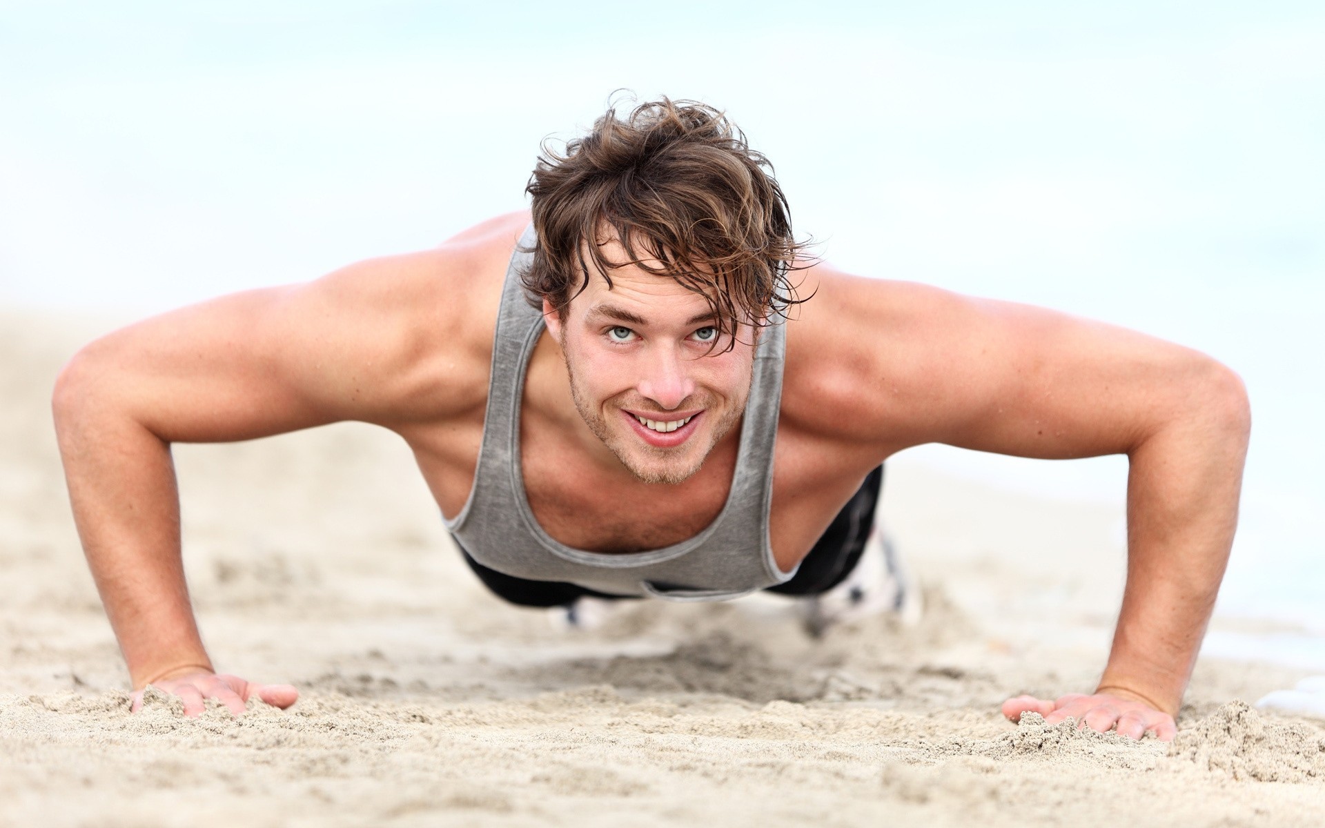 beach man muscles sand