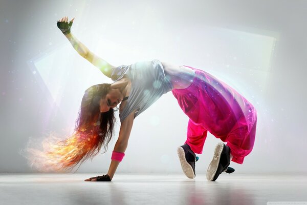 Chica en pantalones de color rosa bailando break