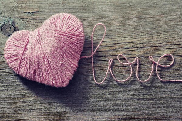 Pink heart made of woolen threads