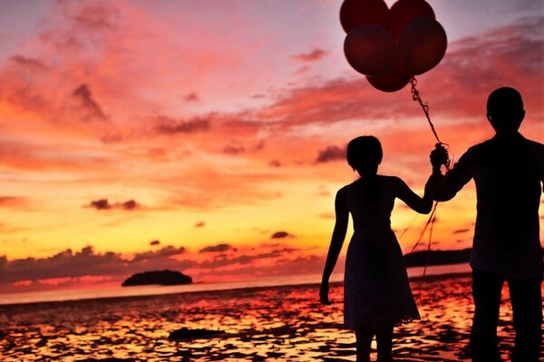 Pareja va con bolas al atardecer