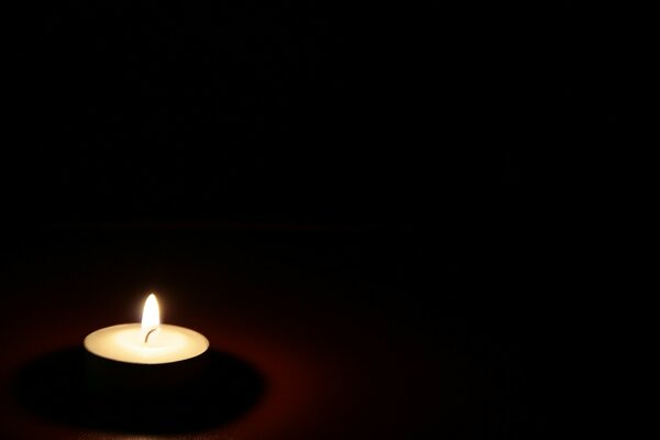 Oscuro, una vela encendida en la mesa