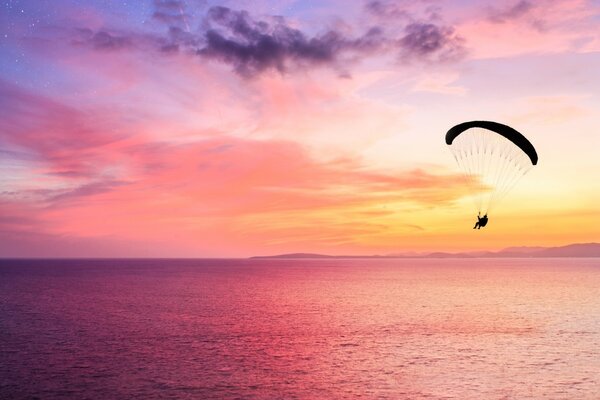 Beau coucher de soleil sur la mer avec un parachutiste