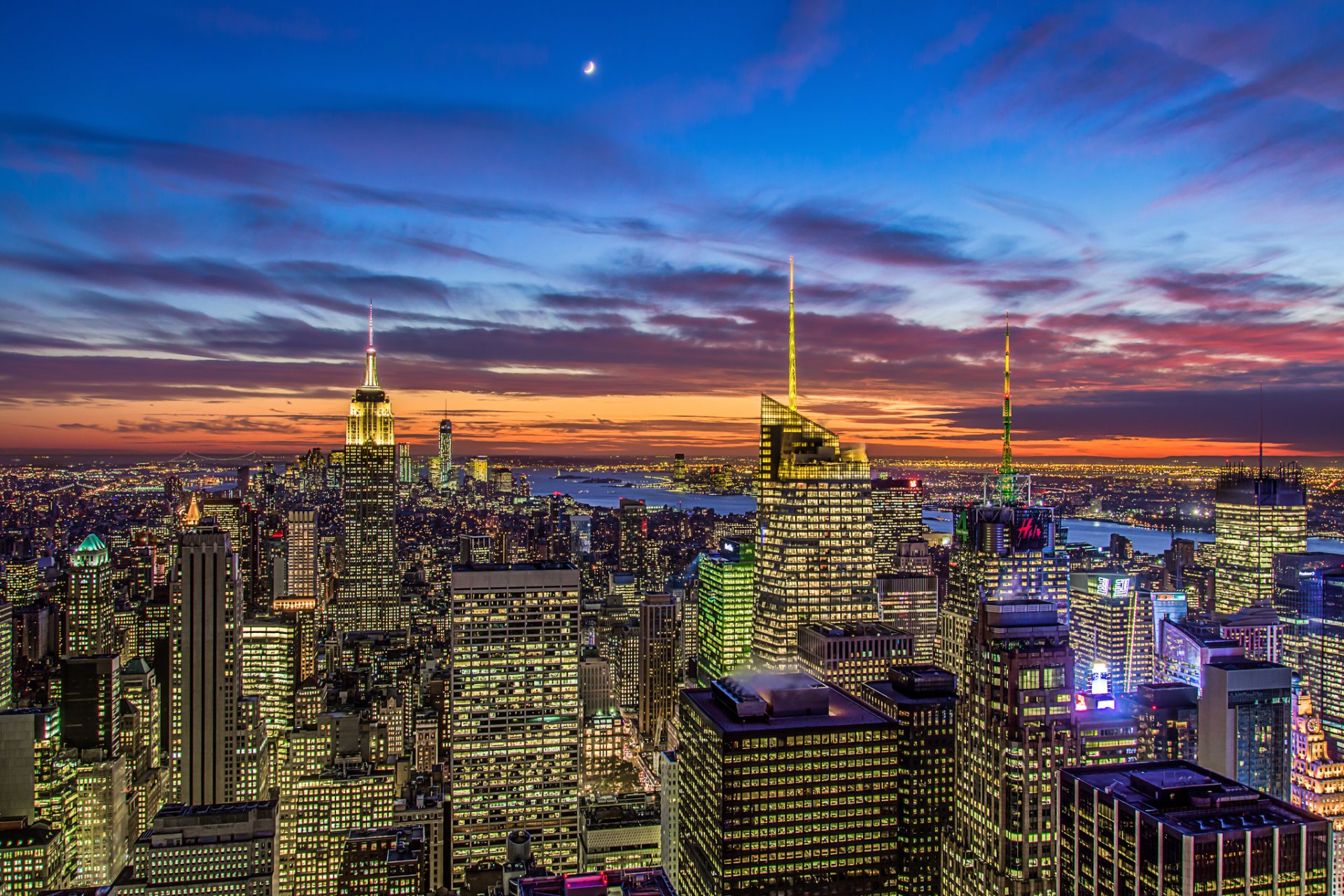 new york usa manhattan empire state building theaterviertel empire state building stadt panorama abend ansicht wolkenkratzer gebäude häuser hochhäuser lichter orange sonnenuntergang blau himmel wolken mond monat