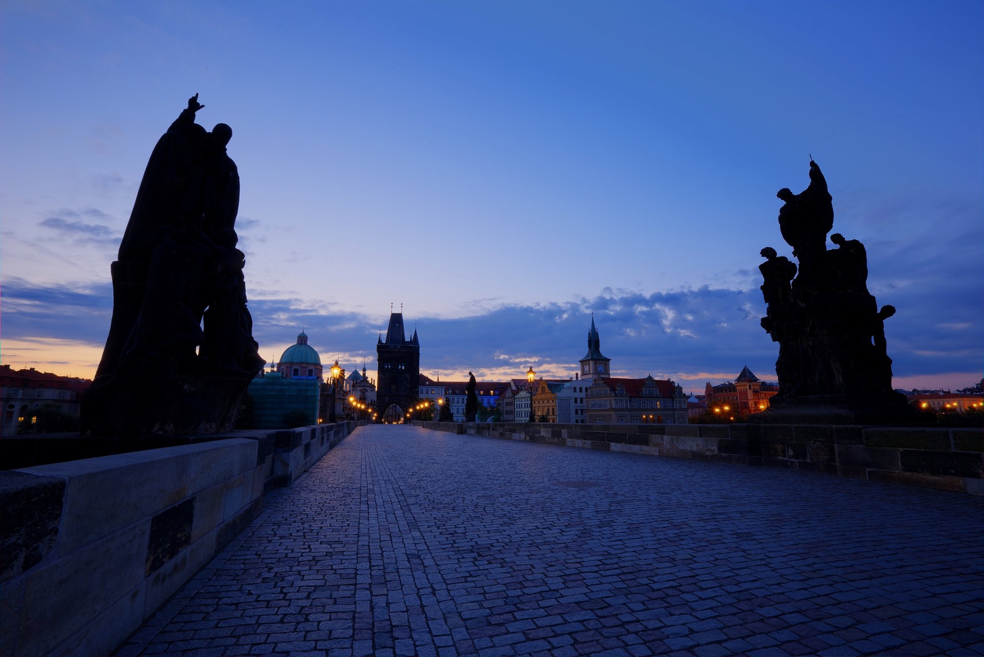 république tchèque prague capitale ville pont charles soirée crépuscule coucher de soleil ciel nuages bleu architecture rétro-éclairage maisons bâtiments lumières lanternes