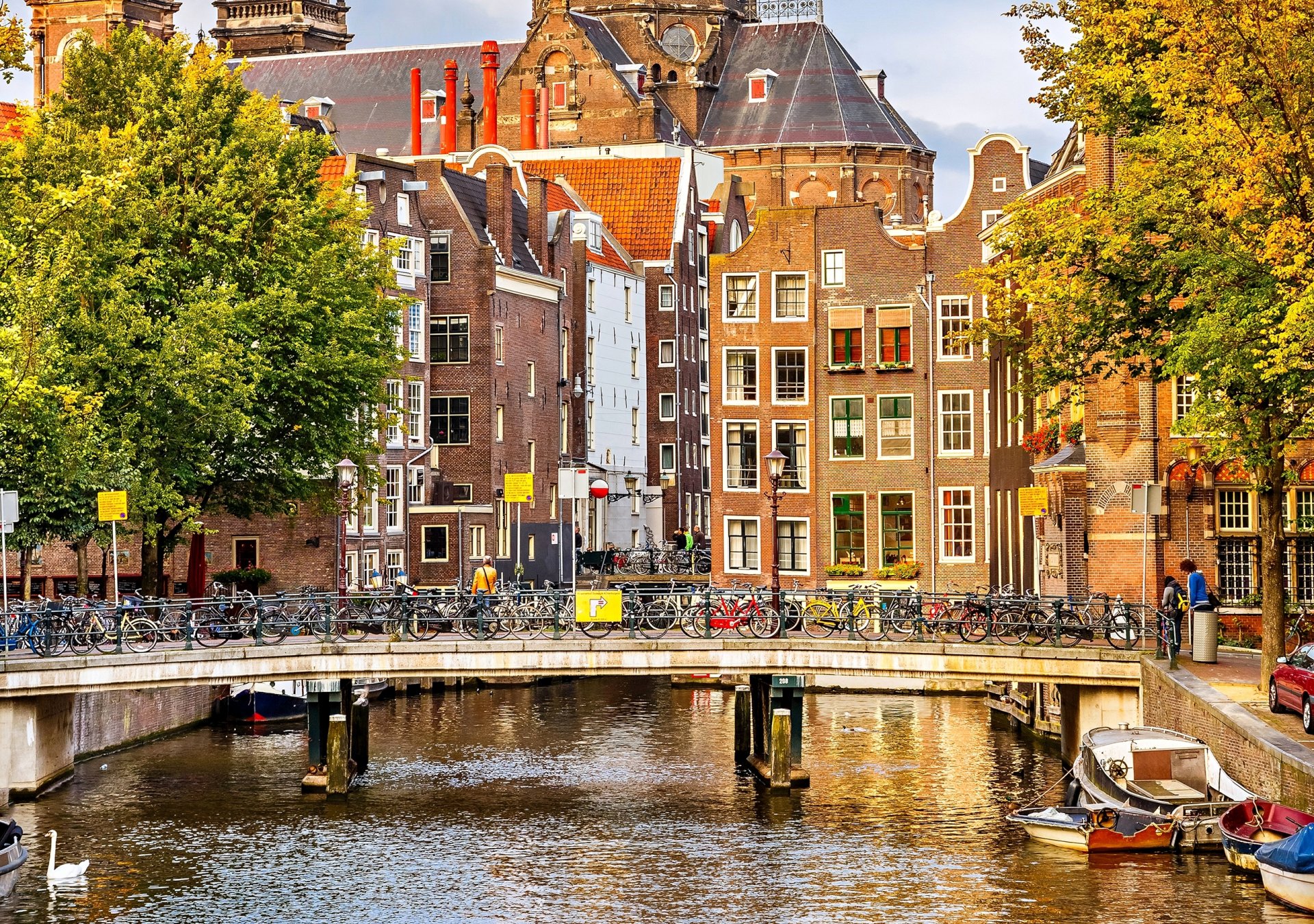 ámsterdam países bajos otoño árboles ciudad casas edificios arquitectura puente bicicletas canal río barcos personas