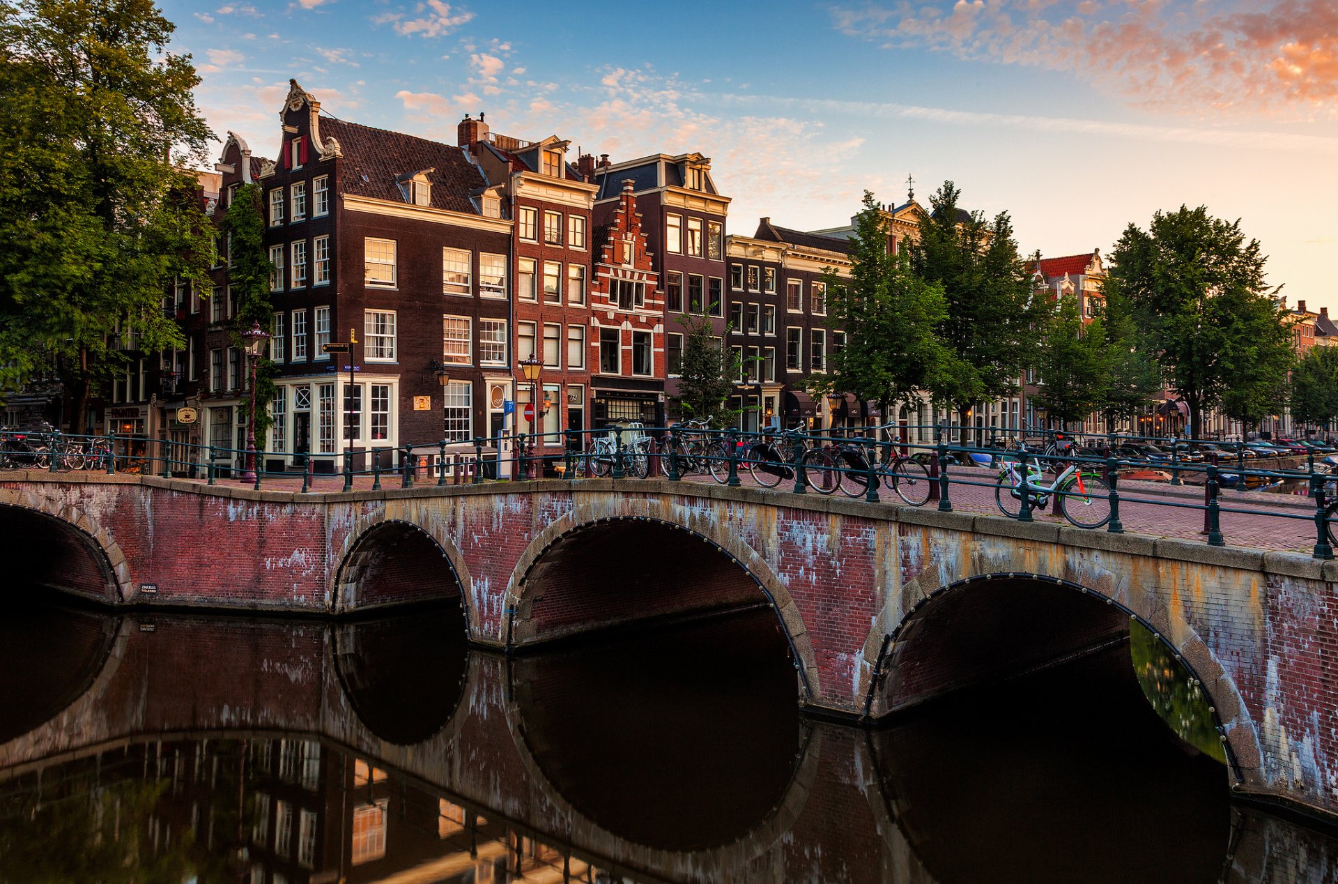 amsterdam netherlands city bridge bicycles canal river houses building