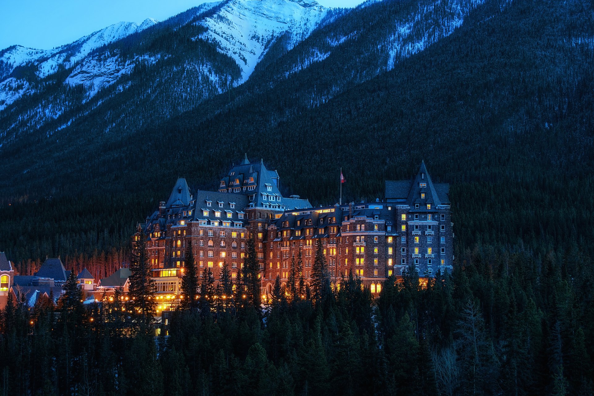 alberta banff national park canada banff national park city mountains hotel trees evening lighting light building