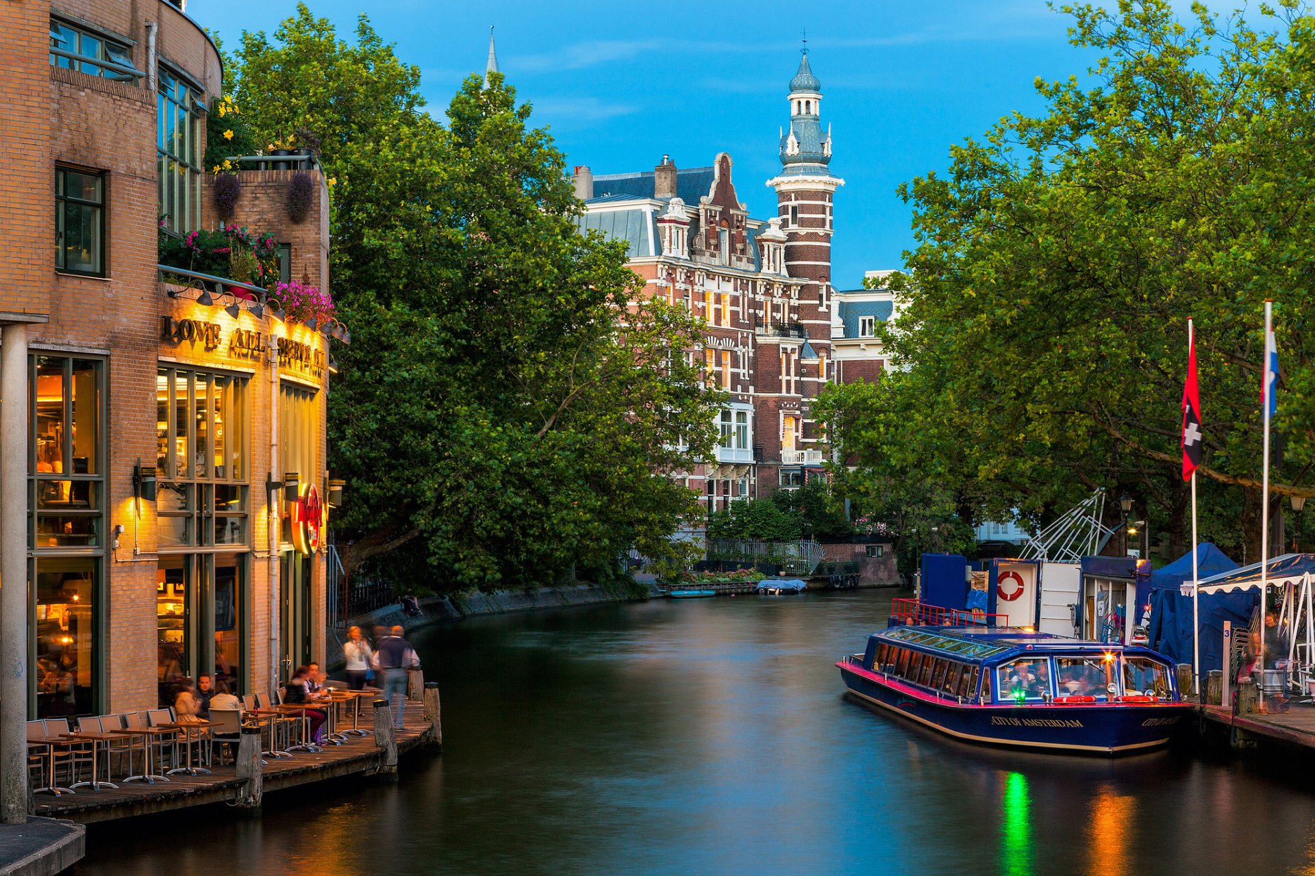 amsterdam ciudad países bajos edificios café arquitectura canal río tranvía río personas naturaleza árboles