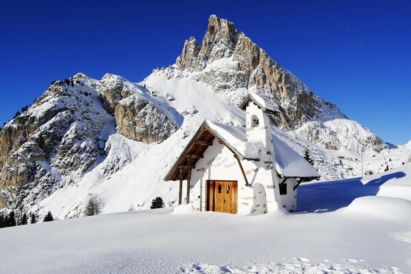 Casa sulla cima di una montagna nella neve