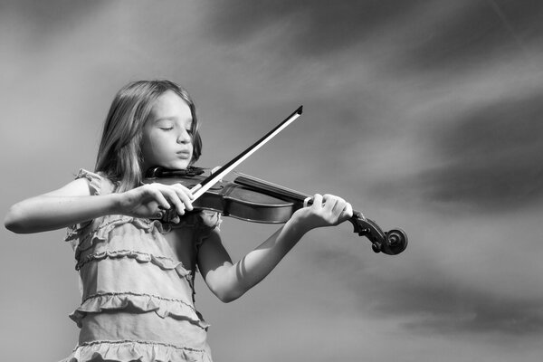 Foto en blanco y negro de una niña con un violín