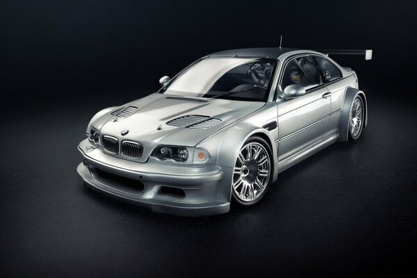 Silver BMW with a body kit on a black background