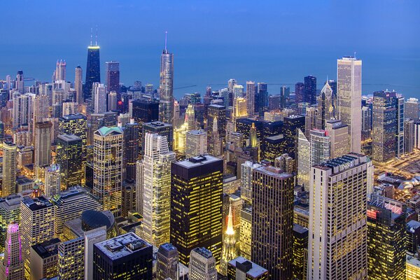 Tall buildings with lights in the windows in the evening