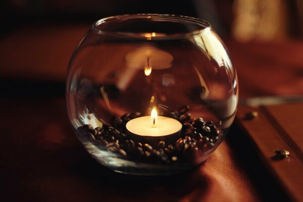 Bougie dans un bocal avec du café sur la table