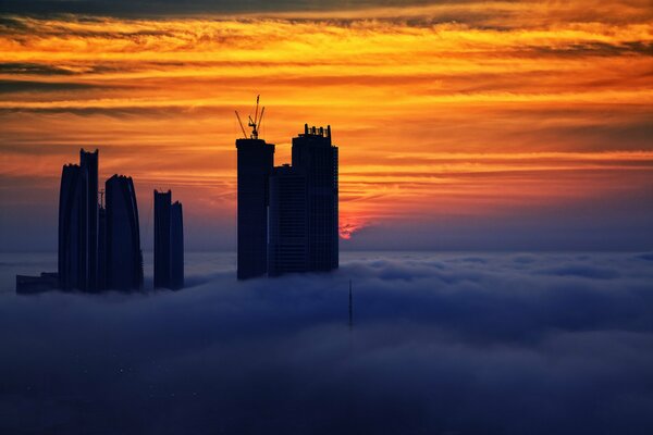 Hohe Gebäude der VAE bei Sonnenuntergang im Nebel