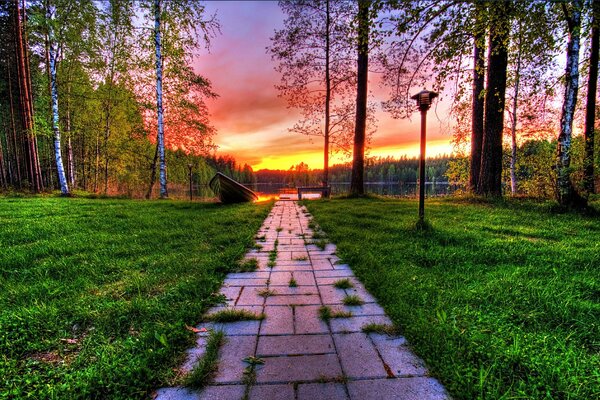 Path through the park to the lake at sunset