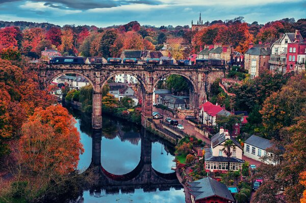 Ciudad de otoño. El cielo se refleja en el río