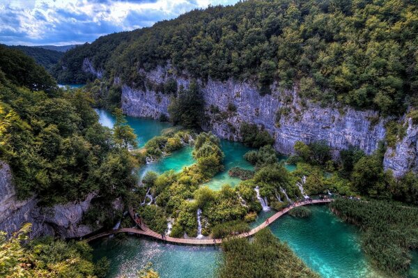 Puente en las montañas sobre el agua azul