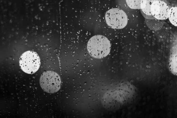 Gouttes de pluie sur le verre et derrière le bokeh