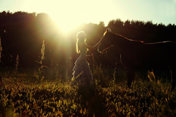 Paseo de verano de una niña por el campo con un caballo