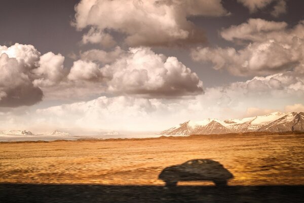 Nubes bajas, campo y montañas en la distancia