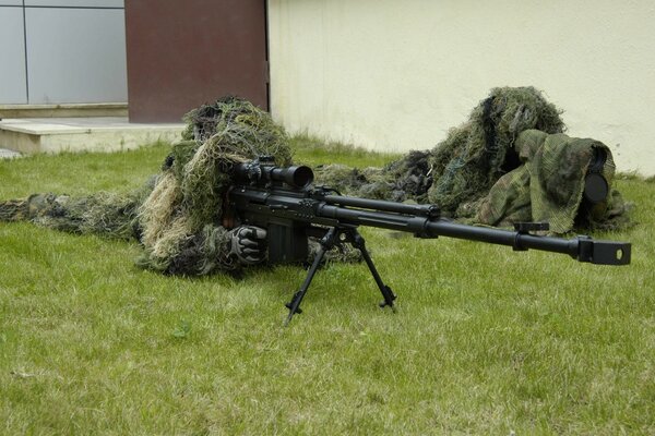 A military man with a sniper rifle on the grass