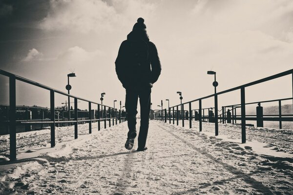 Un uomo cammina lungo la strada, guardando indietro. Male