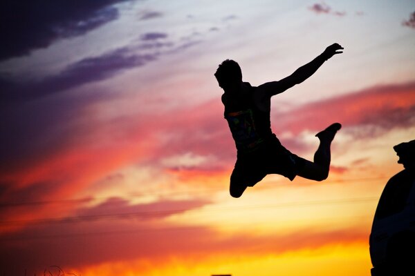 Silhouette d un gars sautant sur fond de coucher de soleil