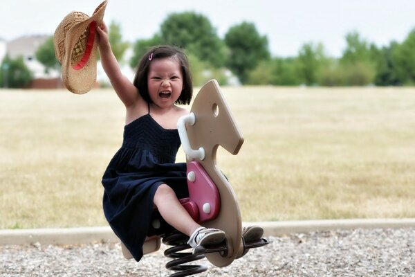 A little girl is sitting on a toy horse