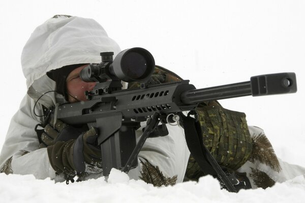 Militaire avec un fusil d assaut couché sur la neige