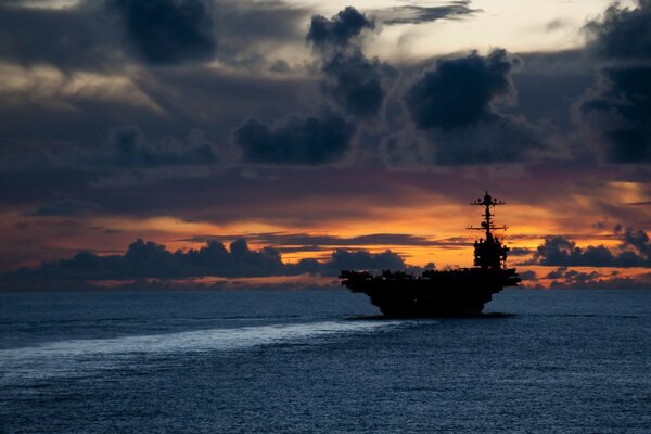 Portaaviones en el mar durante una hermosa puesta de sol