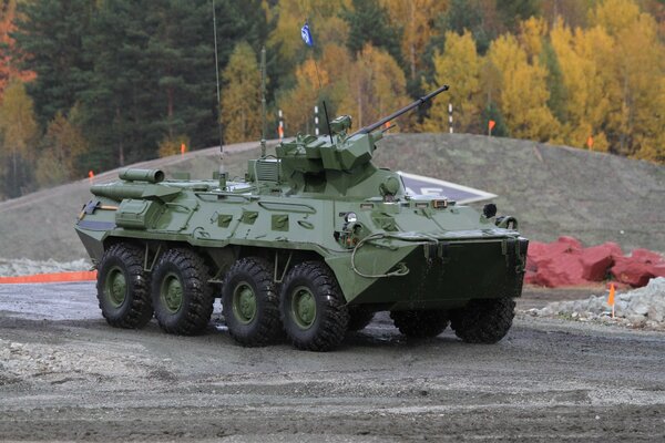 Armored personnel carrier on the background of the autumn forest