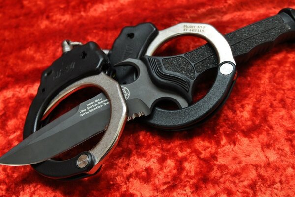 Handcuffs and a knife on a red background