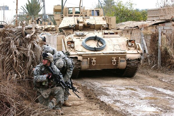 Armed military on the background of a tank