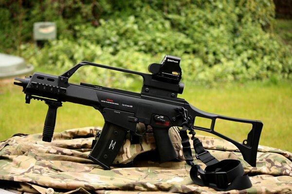 The image of a rifle on a stump against the background of a forest