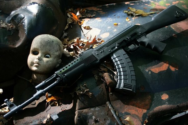 Machine gun on the background of leaves and abandoned toys