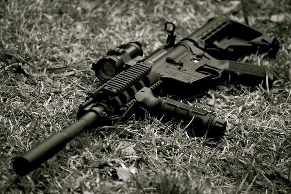 Foto en blanco y negro de un rifle en la hierba