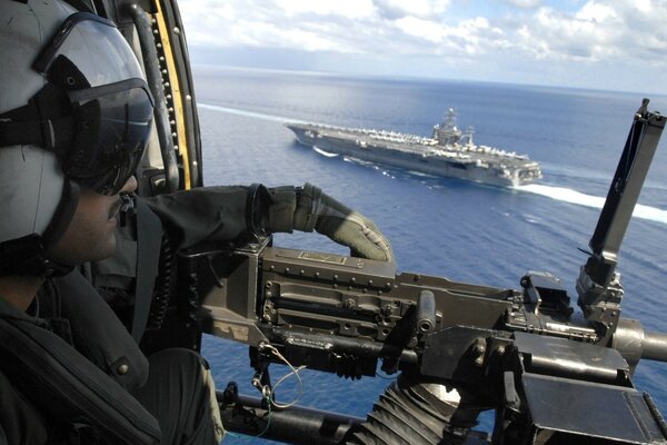 An armed pilot flies over the sea