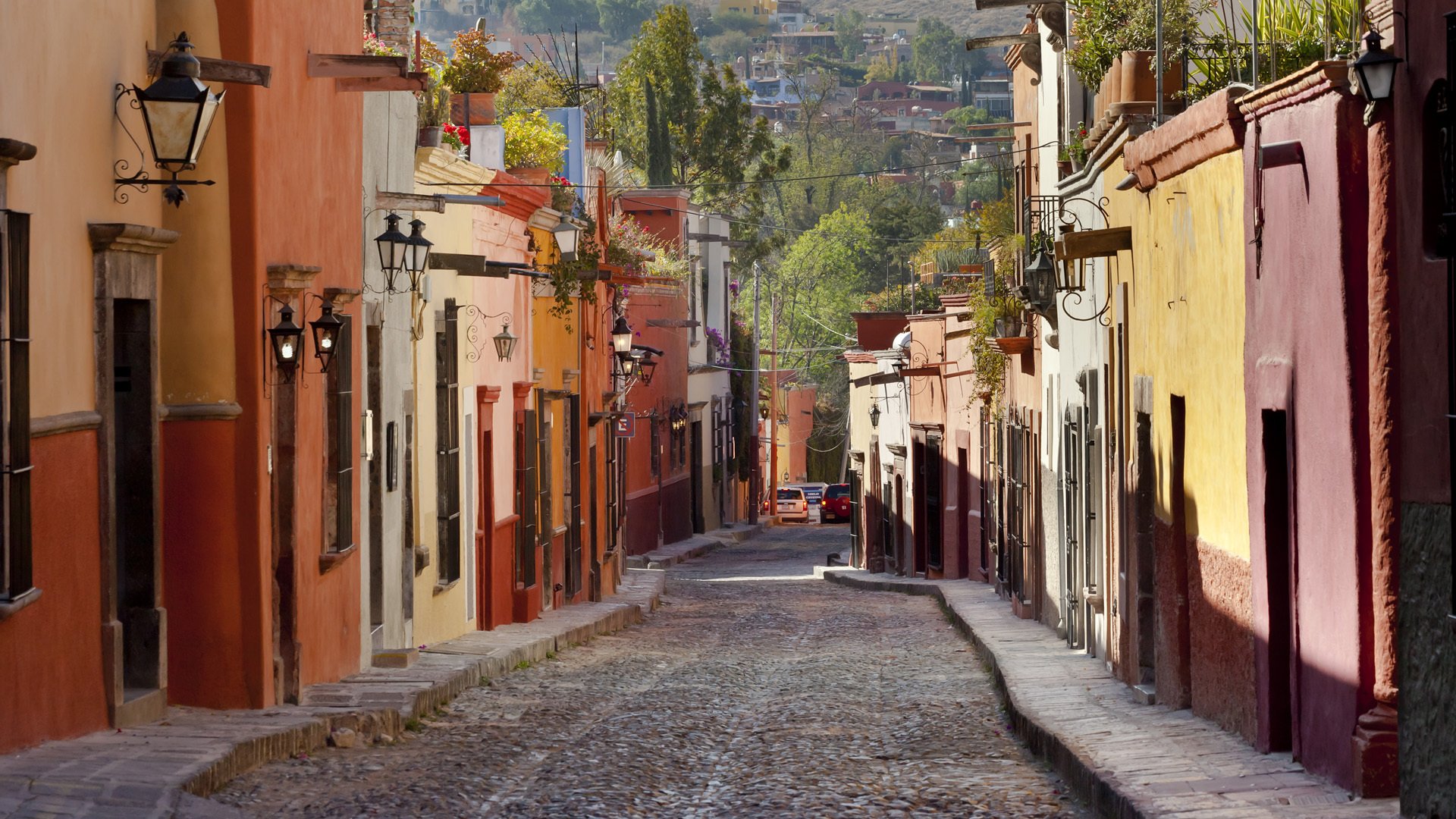 calle casas acera alambres linternas camino coches árboles