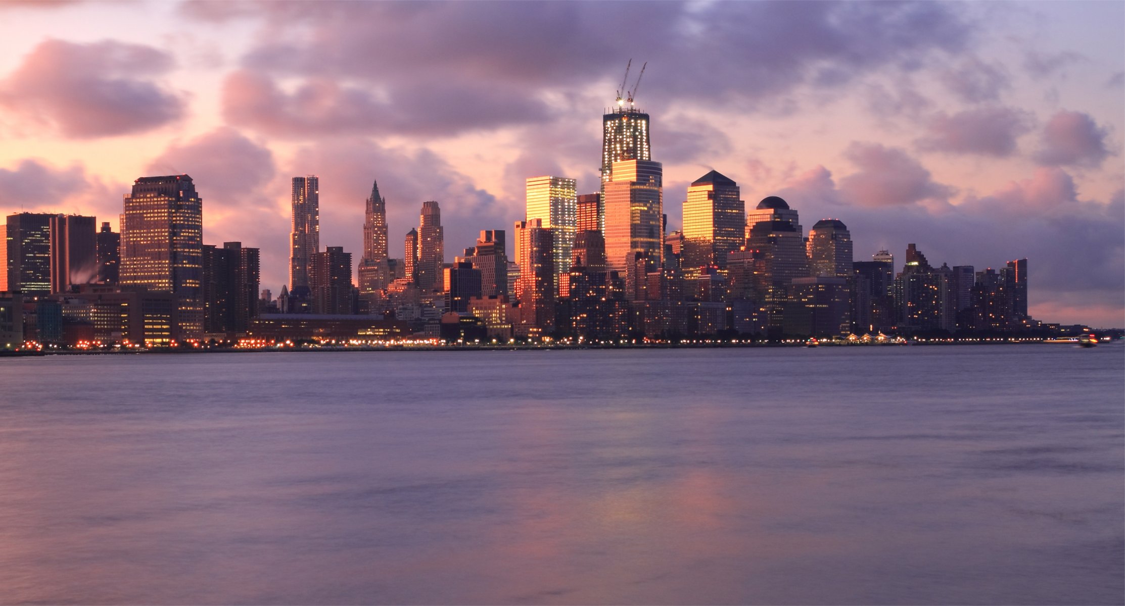 estados unidos nueva york metrópolis edificios rascacielos iluminación luces río noche rosa puesta de sol cielo nubes nubes