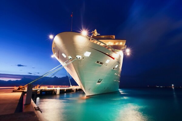 A big white ship on the dock at night