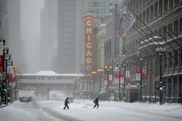 Les gens traversent une rue enneigée de Chicago en hiver