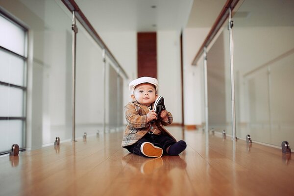 Garçon avec une chaussure. Bébé avec une chaussure dans les mains