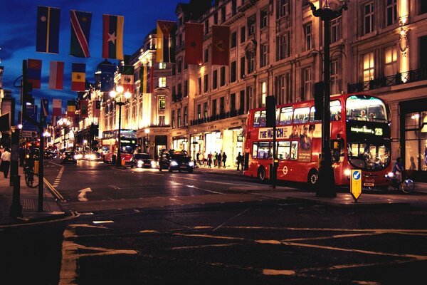 Buses, cars, people on an evening street in central London