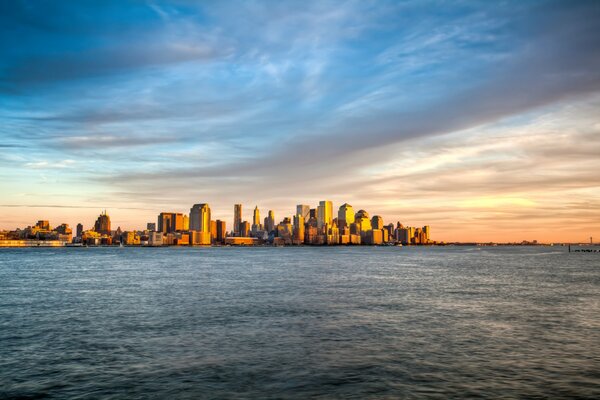 Sonnenuntergang über dem Meer vor dem Hintergrund von Manhattan in New York