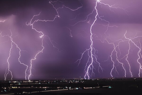 Sopra la città nel cielo notturno fulmine