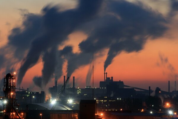 Smoke from factory chimneys against the night sky