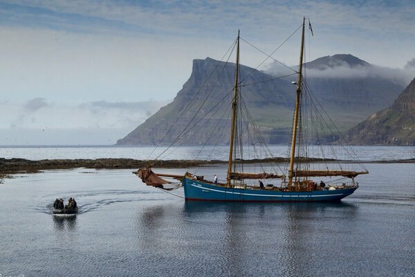 Yacht vor dem Hintergrund der Berge auf den Färöer-Inseln