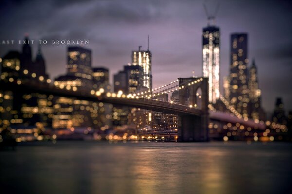 A city with a bridge over a river at night