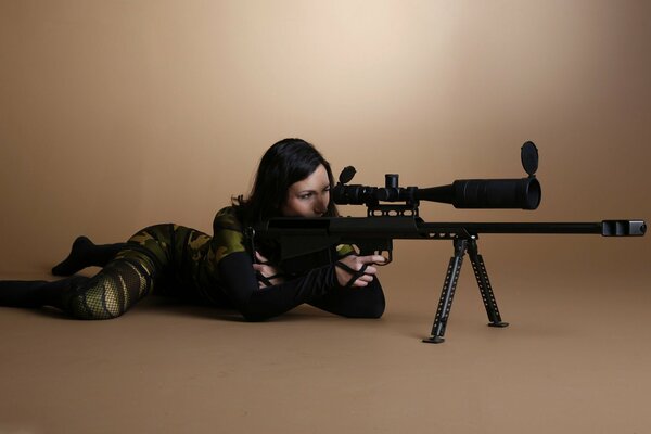 A girl in a tight-fitting suit looks into the sight of a rifle